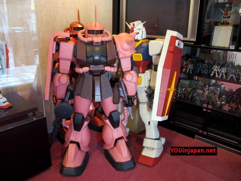 un gundam e uno zaku gigante dentro l'edificio della sunrise a kamiigusa tokyo